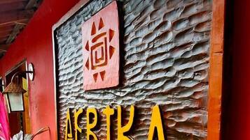 A wooden sign with the name "AFRIKA Pousada" and decorative elements.