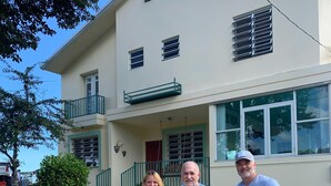 Una casa a due piani con un balcone, un portico e una strada privata.