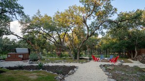 Ein Garten mit einer Kiesfläche, Sitzgelegenheiten in Rot und Blau sowie einem Whirlpool.