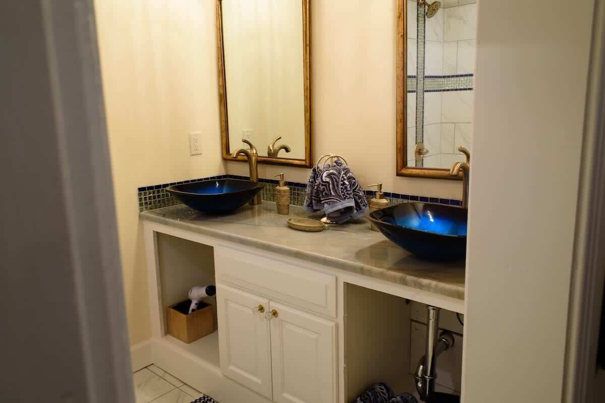 Un baño con dos lavamanos, un espejo y un perchero para toallas.