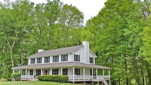 A large, two-story house with a wrap-around porch, surrounded by lush green trees. - Restful Rustic Farmhouse on Lake Cumberland (Jamestown)
