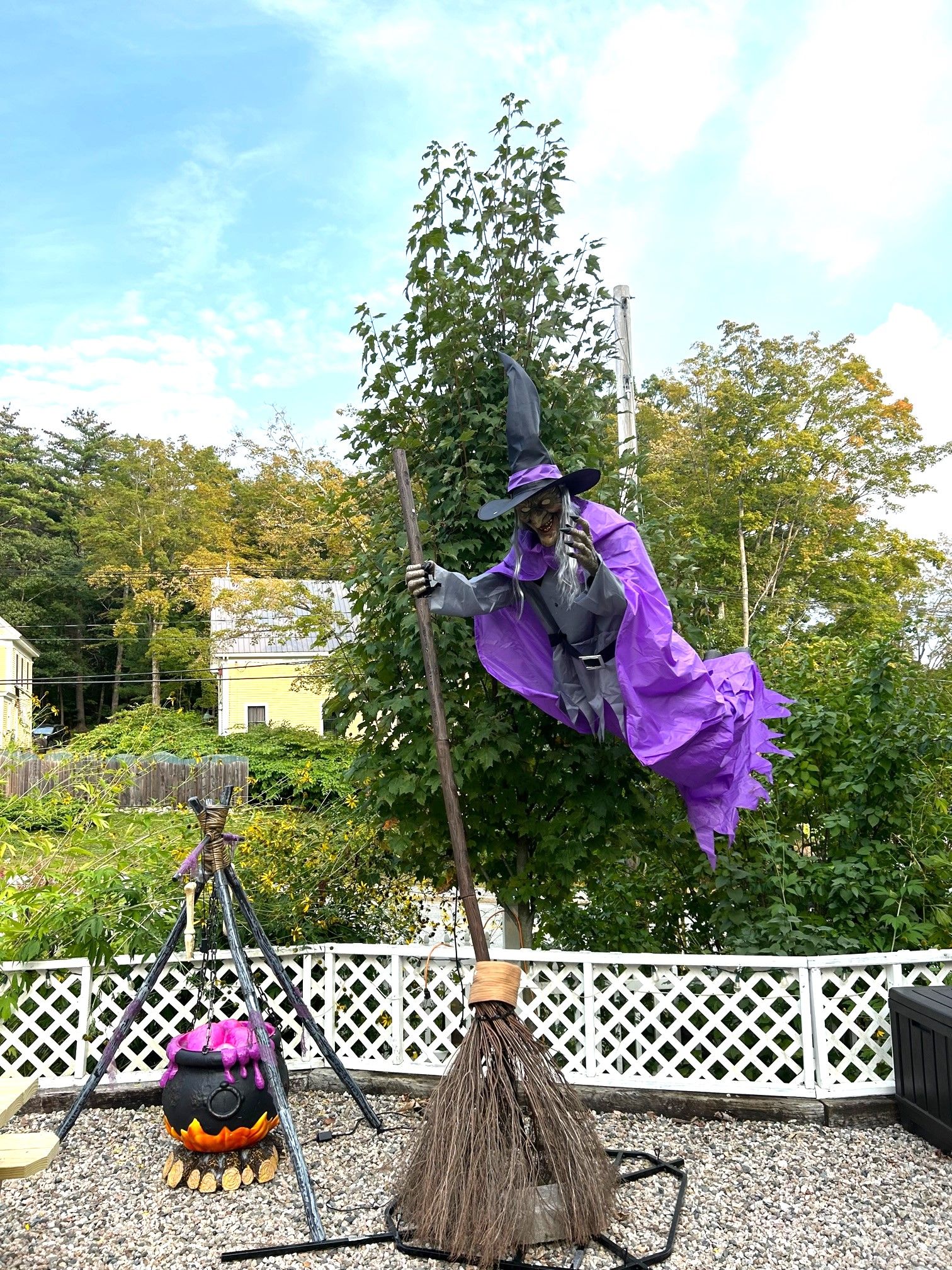 Une décoration sur le thème d’Halloween représentant une sorcière volant sur un balai, un chaudron et un chapeau de sorcière.
