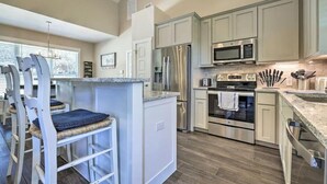 A kitchen with white cabinets, stainless steel appliances, and a granite countertop.