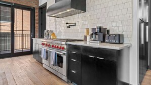 A modern kitchen with a stainless steel range, a built-in oven, and a coffee maker.