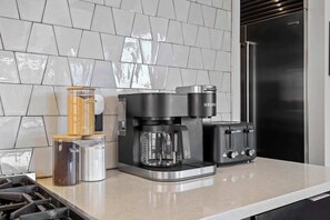 A kitchen with a coffee maker, toaster, and containers on the counter. - Nashville WeHo Escape | Walk to Bars & Dining (Nashville)