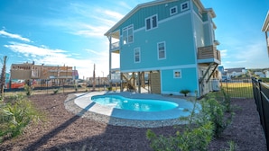 A two-story building with a pool in the backyard.