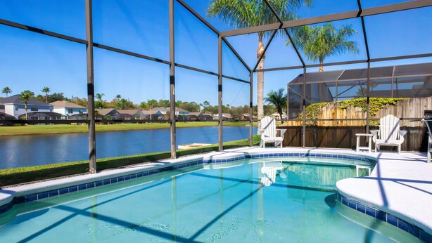 A swimming pool with a view of a lake and houses in the background.