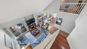 A spacious living area with a sofa, coffee table, and a dining area with chairs and a table.