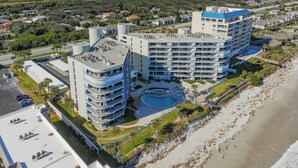 Ein mehrstöckiges Hotel mit Pool in Strandnähe.