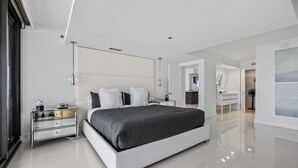 Ein modernes Schlafzimmer mit einem großen Bett, Nachttischen und einem Spiegel.