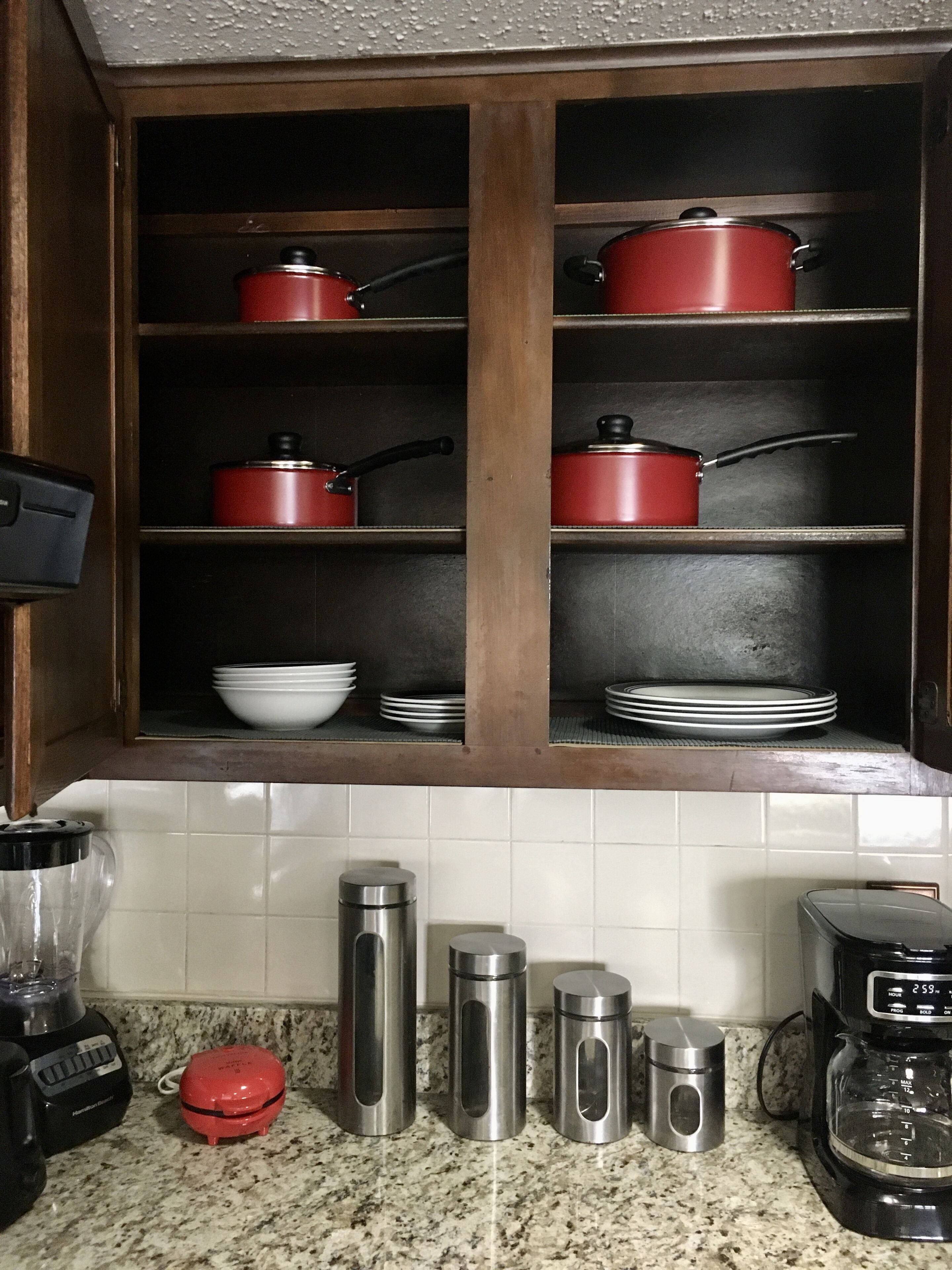 A kitchen with wooden cabinets, stainless steel appliances, and a granite countertop.