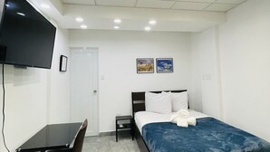 A modern bedroom with a bed, a desk, a chair, a TV, and two framed pictures on the wall. - 5 Start* New Beautiful Cozy Apart in San Juan P.R (San Juan)