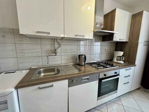 Réfrigérateur, un four, surface de cuisson, lave-vaisselle