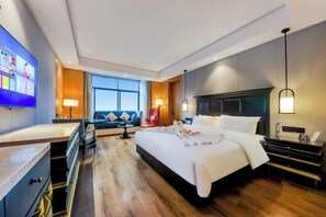 A modern hotel room with a large bed, a desk, a sofa, and a TV. - General Hotel (Longquan)