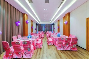 A banquet hall with rows of tables and chairs, a wooden floor, and a long corridor. - General Hotel (Longquan)