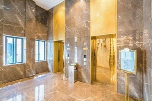A lobby with marble walls, a reception desk, and a signboard. - General Hotel (Longquan)