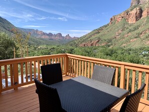A wooden deck with a table and chairs, overlooking a mountainous landscape. - Your Sedona Red Rocks Escape at Oak Creek Canyon! (Sedona)