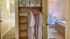 A walk-in closet with a wooden shelf, a hanging rack, and a bench with a blanket. - Your Sedona Red Rocks Escape at Oak Creek Canyon! (Sedona)