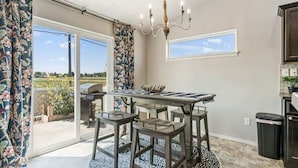 A dining area with a table and chairs, a chandelier, and a view through large sliding glass doors. - Private Wine Country Retreat | South Nampa | Sleeps 10 (Nampa)