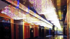 A corridor with reflective floors and walls, adorned with hanging decorative lights. - Jinjue Hotel (Nearby Train Station) (Huizhou)