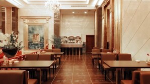 A hotel lobby with a central bar, seating area, and a chandelier. - Jinjue Hotel (Nearby Train Station) (Huizhou)