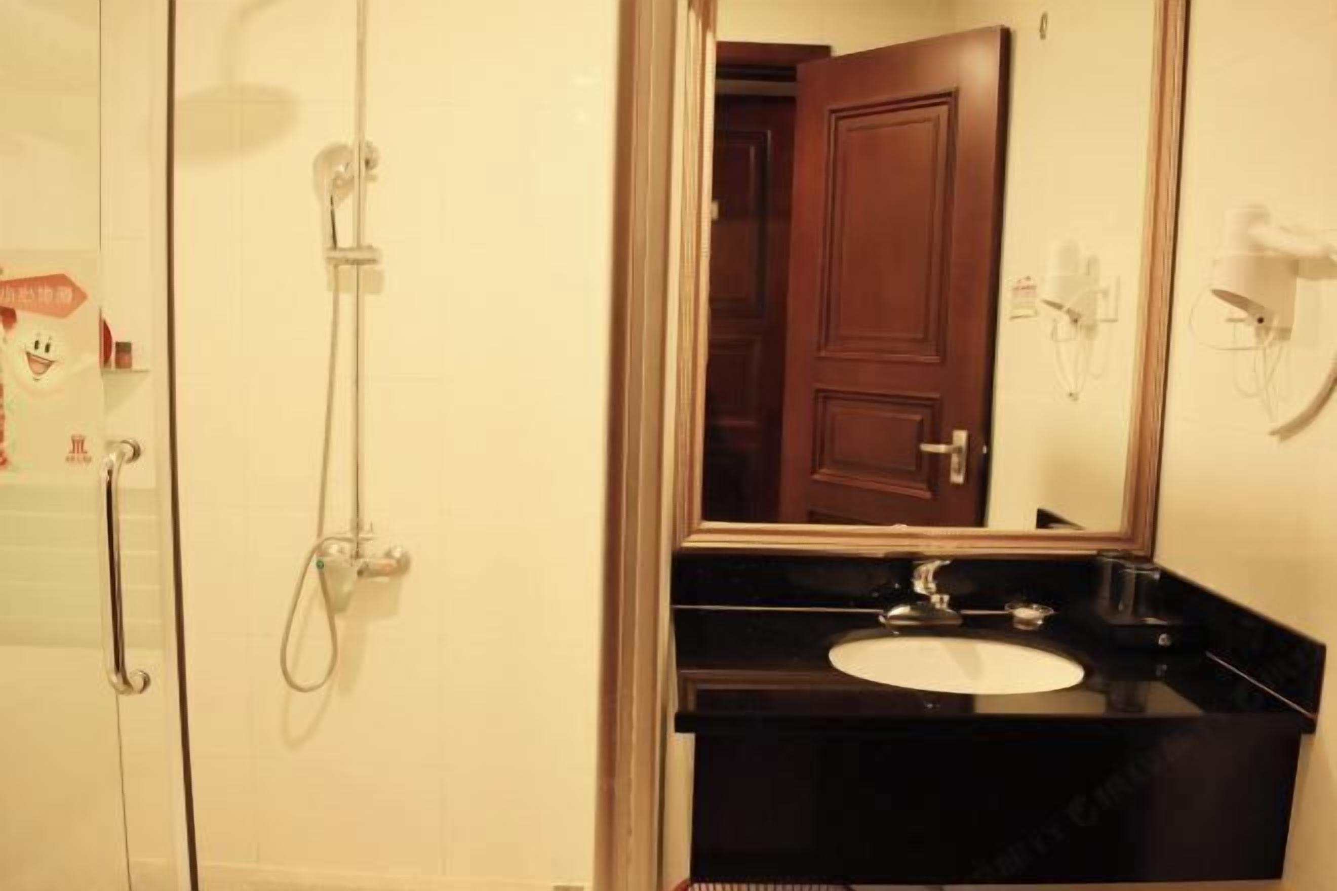 Un baño con un lavabo negro, un espejo y una ducha.