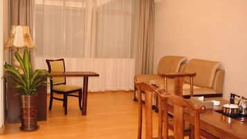 Una habitación con una mesa de comedor, sillas, un sofá, una lámpara y una planta en maceta.