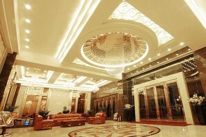 A spacious lobby with a grand chandelier, a seating area, and a large entrance. - Jinjue Hotel (Nearby Train Station) (Huizhou)