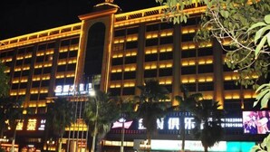 A multi-story hotel with illuminated signage and a prominent entrance. - Jinjue Hotel (Nearby Train Station) (Huizhou)