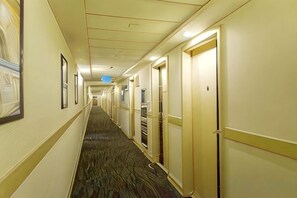 A hotel hallway with doors on both sides, carpeted floors, and framed pictures on the walls. - Jincheng Hotel (Bazhou Shengfang Town) (Bazhou)