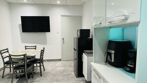 A modern kitchen with a dining area, a flat-screen TV mounted on the wall, and a refrigerator. - 5 Start* *New Lovely apartment in San Juan P.R. (San Juan)