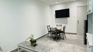 A modern living room with a sofa, a coffee table, a dining table with chairs, a flat-screen TV mounted on the wall, and a kitchen area with a refrigerator. - 5 Start* *New Lovely apartment in San Juan P.R. (San Juan)