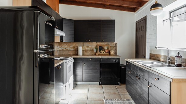 A modern kitchen with dark cabinetry, a stainless steel refrigerator, and a wooden ceiling. - NEW: Charming Desert Abode! Centrally located, near UofA & downtown Tucson (Tucson)