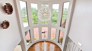 A staircase with multiple windows leading to a terrace with a red-tiled roof. - Tropical Treehouse with Private Pool - 3BR/2.5B (Manuel Antonio)