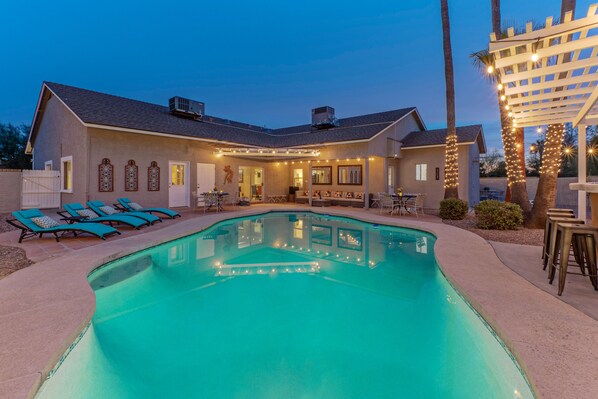 A house with a swimming pool, outdoor seating, and string lights. - ADA Access, One Story, Htd POOL, Spa, Putting Green, Games, Fire Pit, TVs All BRs (Scottsdale)