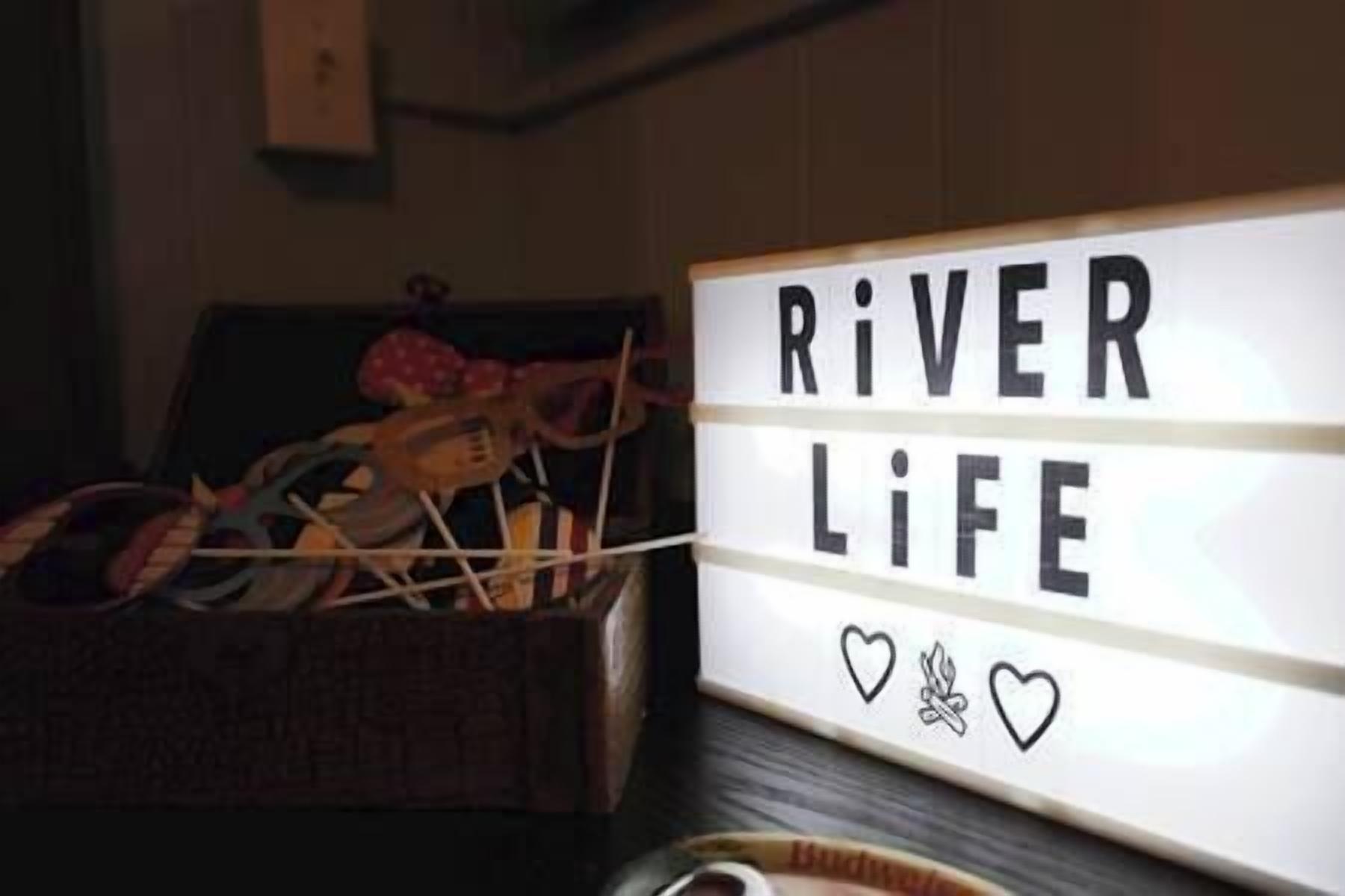 Ein Schild mit der Aufschrift „RIVER LIFE“ und zwei Herzsymbolen.