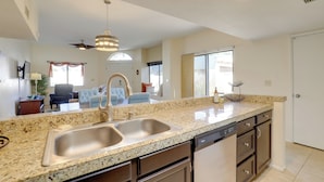 A kitchen with granite countertops, stainless steel sink, and a dishwasher. - Sunny Tucson Townhome w/ Patio & Mountain Views! (Tucson)