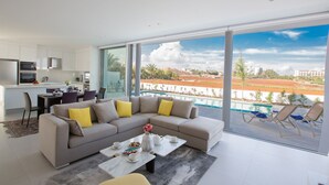 A modern living room with a large sectional sofa, a coffee table, and a dining area. - Protaras Holiday Villa Bp3 (Protaras)