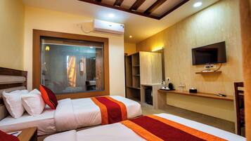 Une chambre d’hôtel avec deux lits, une télévision, un appareil de climatisation et une fenêtre donnant sur l’extérieur.