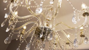Un lustre orné de nombreux éléments de cristal et de détails dorés.