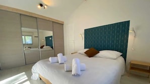 A modern hotel room with a large bed, a mirror, and a wooden floor. - Villa pool & SPA on the Arcachon basin (Lanton)