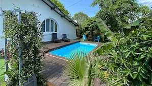 A backyard with a swimming pool, wooden deck, and outdoor furniture. - Villa pool & SPA on the Arcachon basin (Lanton)