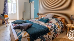 Une chambre à coucher comprenant un lit, une chaise, une fenêtre et une tête de lit en lattes de bois.