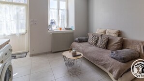 Un salon moderne avec un canapé, une petite table basse ronde et une fenêtre donnant sur un beau paysage.