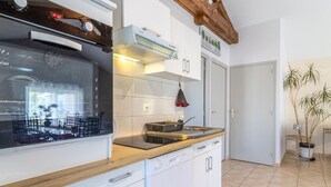 Eine moderne Küche mit weißen Schränken, einer Holzarbeitsplatte und einem eingebauten Backofen.