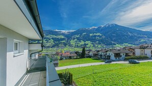 A residential area with houses, a clear sky, and a mountain range in the background.