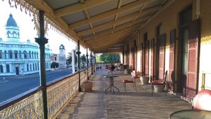 Un espace extérieur abrité, doté d’une rambarde, de tables et de chaises.