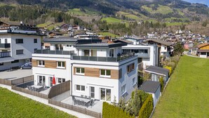 Un moderno edificio residencial con techo plano, ventanas amplias y un balcón.