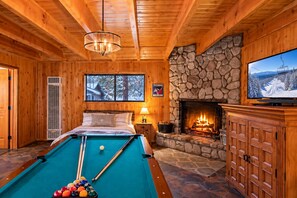 A cozy room with a pool table, a fireplace, and a television. - Main House + Guest House · Spa · Game Room (Big Bear)