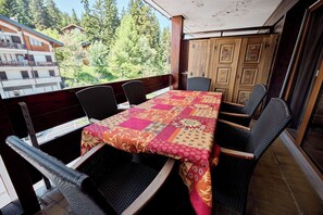 A dining area with a table covered by a patchwork tablecloth, surrounded by wicker chairs. - Located in Les Collons 1850, only 50 meters from the ski-lifts "La Joc" and "Petit Vallon" (crossbow (Thyon-Les Collons)